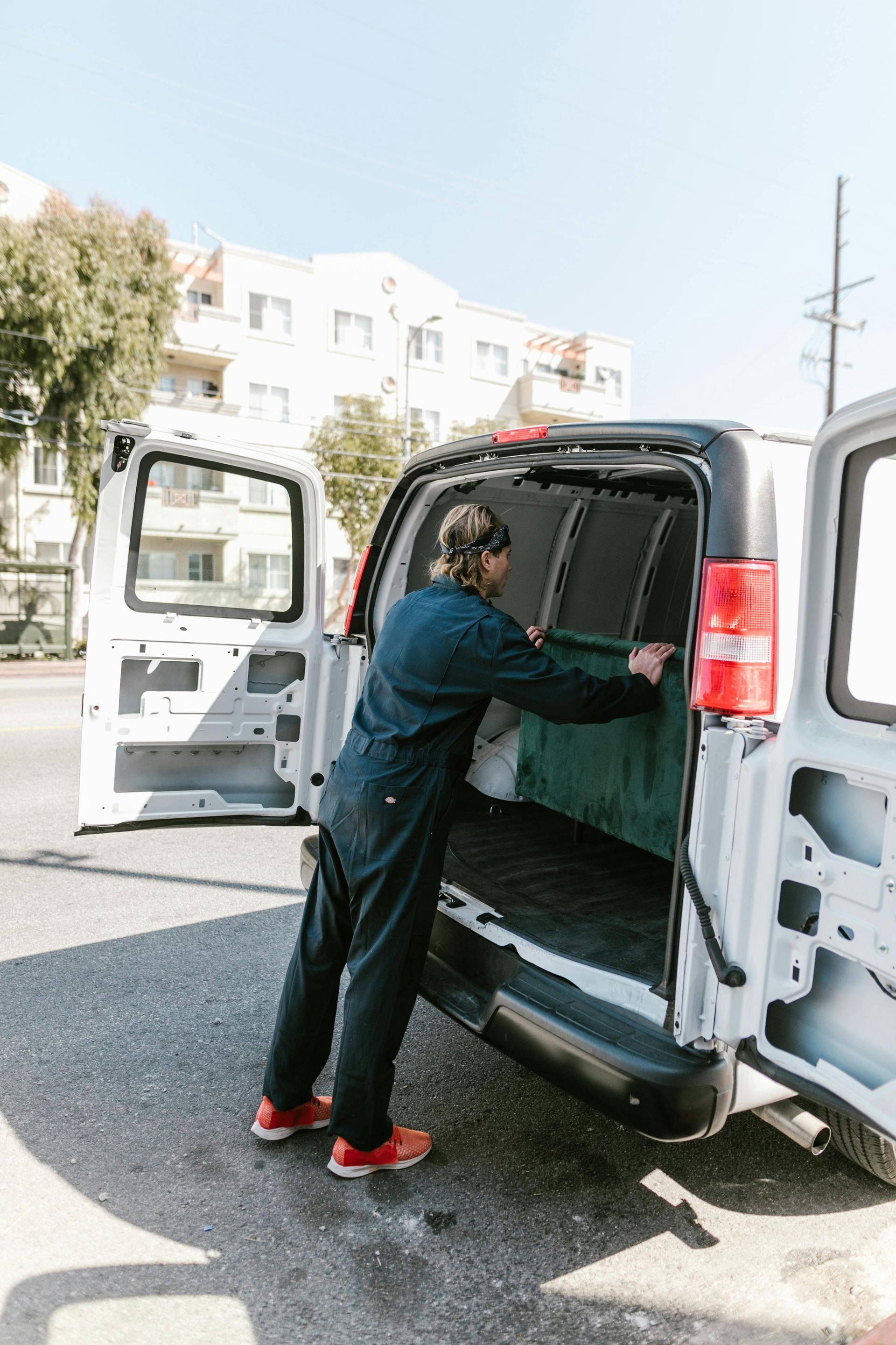 A Man Is Loading Something Into The Back Of A Van — Ahern's Removals In Inverell, NSW