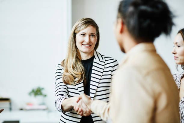 A group of women are shaking hands in an office.