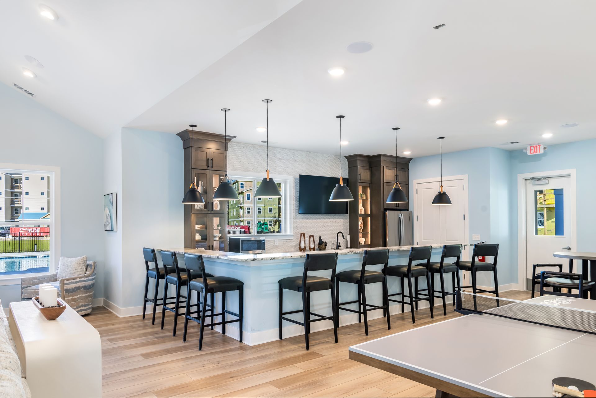 Bar area with seating, pendant lights, and a ping pong table.