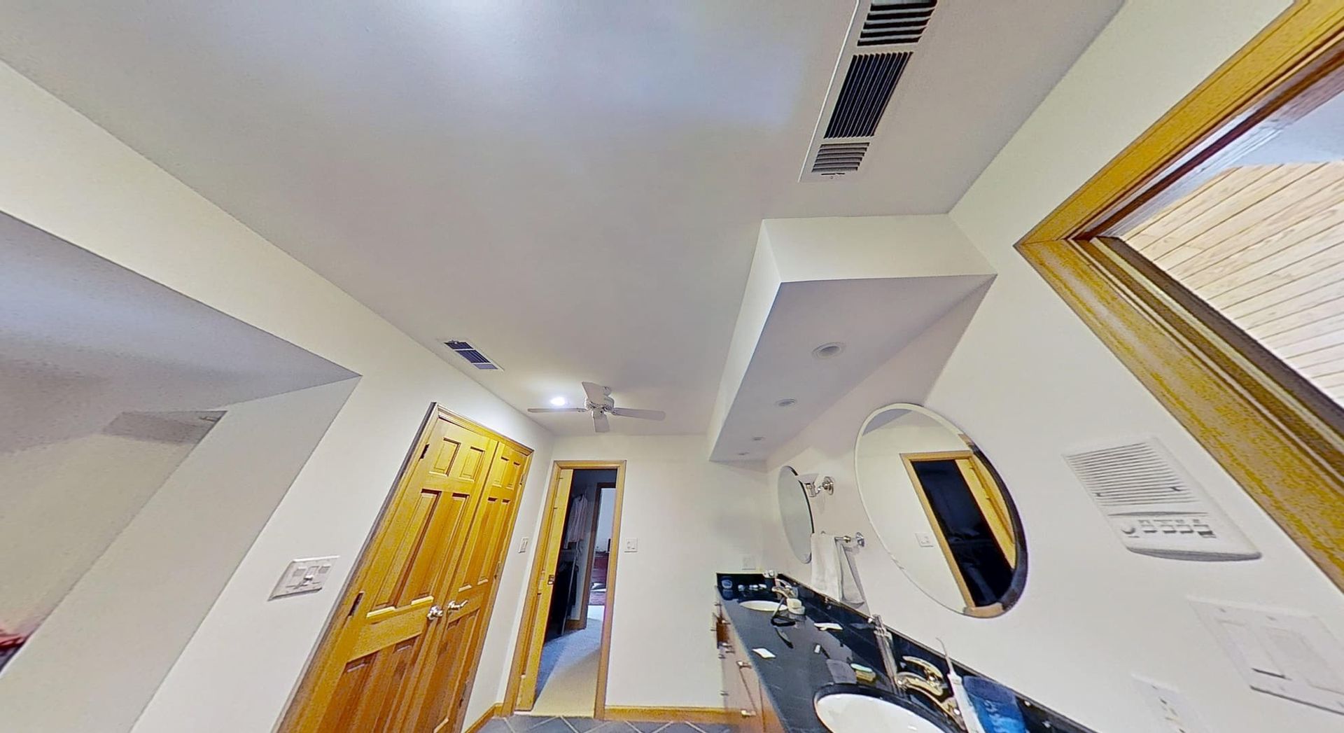 Bathroom ceiling fully repaired after water damage restoration, alternate angle