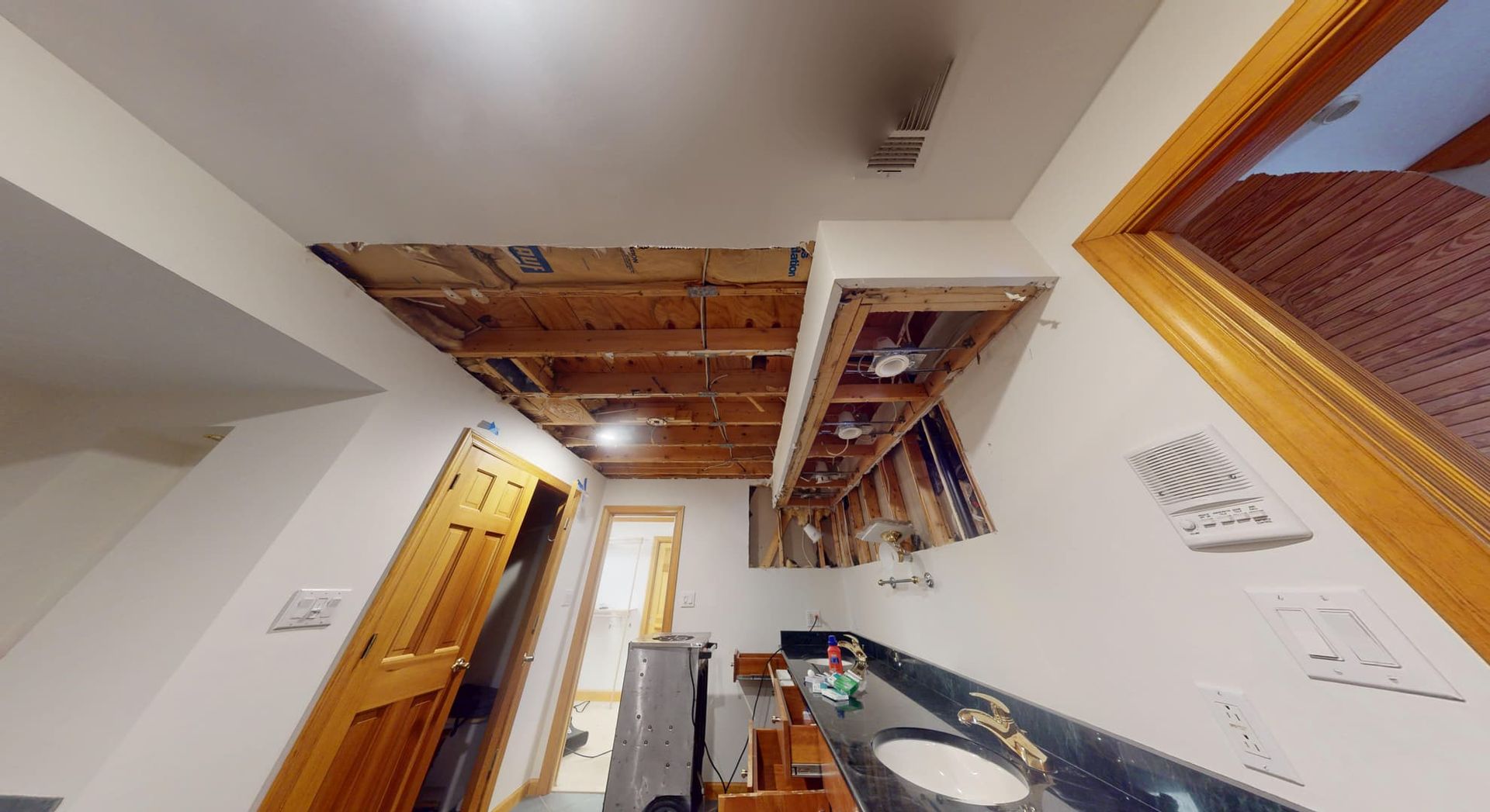 Bathroom ceiling water damage from another angle showing staining before restoration