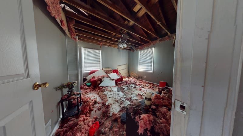 Bedroom area before fire restoration showing damaged drywall and smoke-stained surfaces