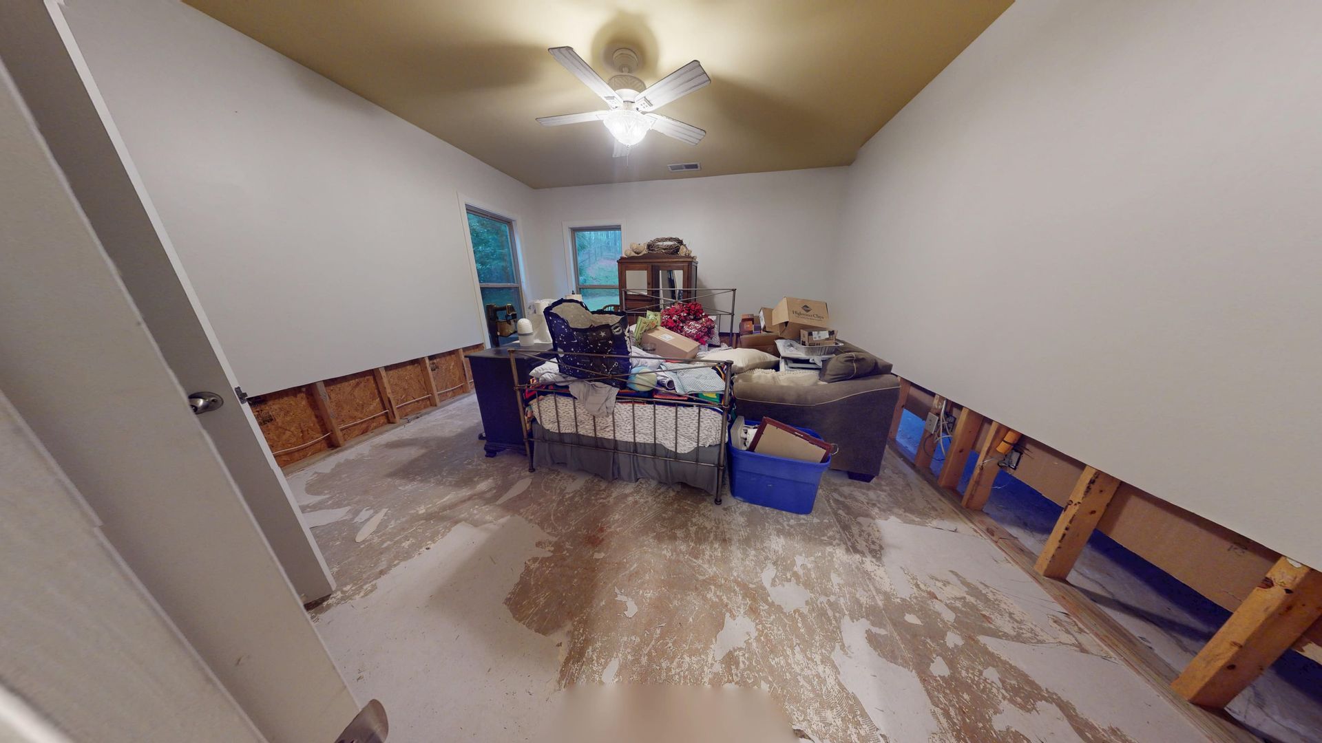 Bedroom with water-soaked flooring and flood damage before cleanup
