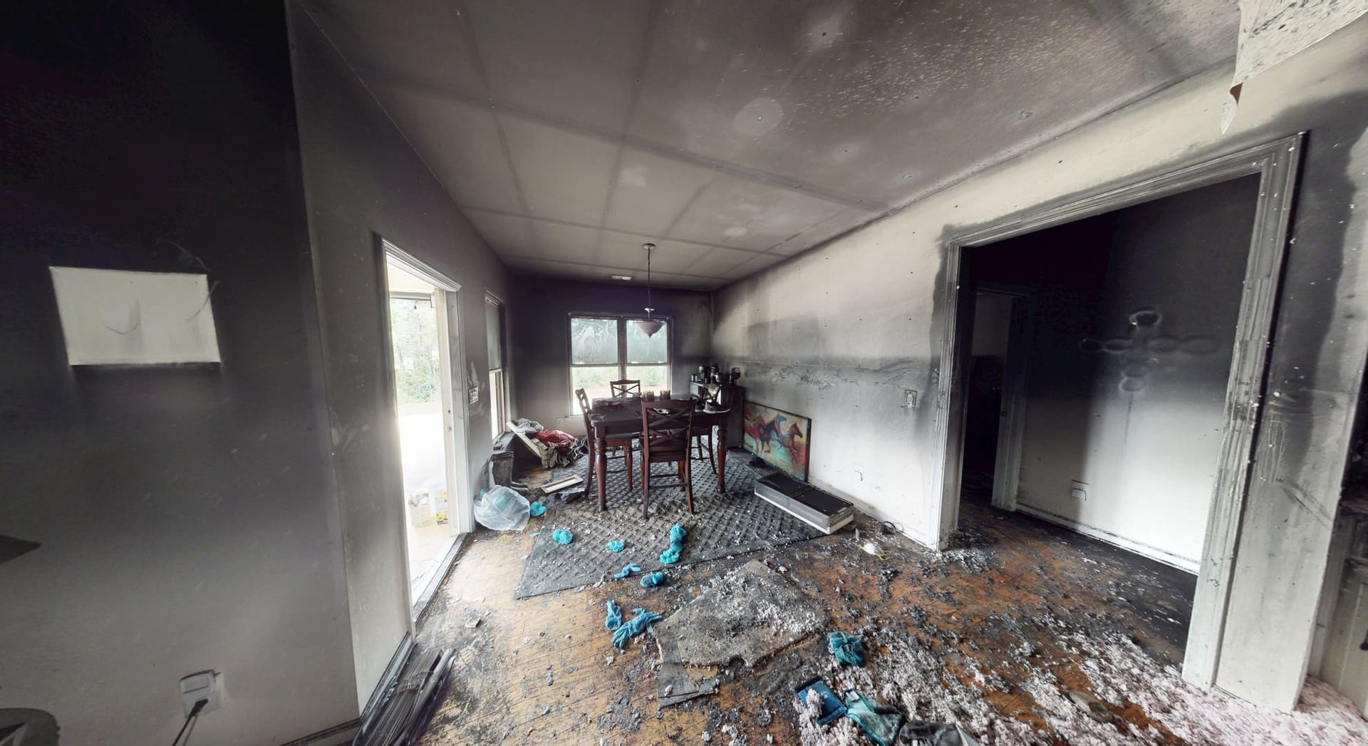 Dining room before fire damage restoration showing charred walls and debris