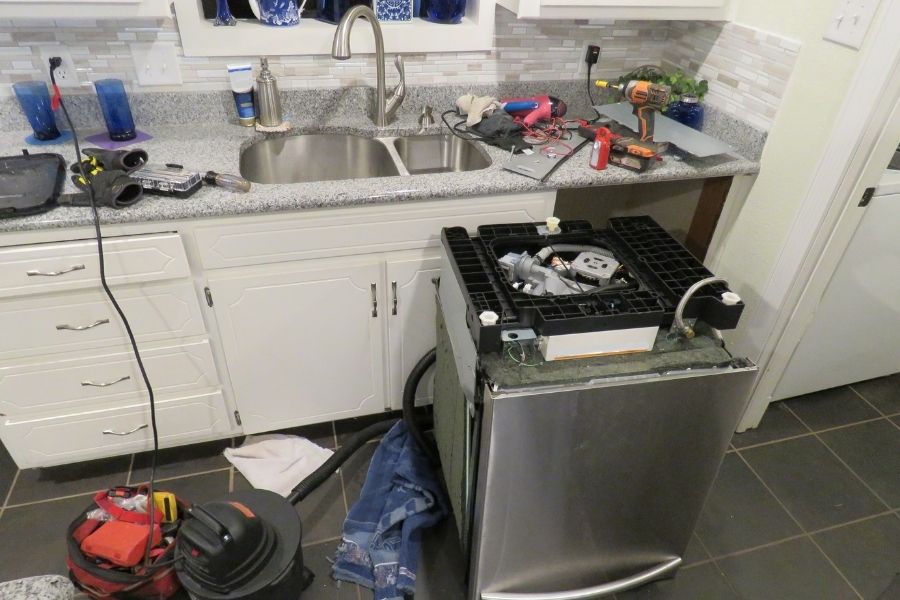 Water pooling on a kitchen floor from a leaking dishwasher in a residential home