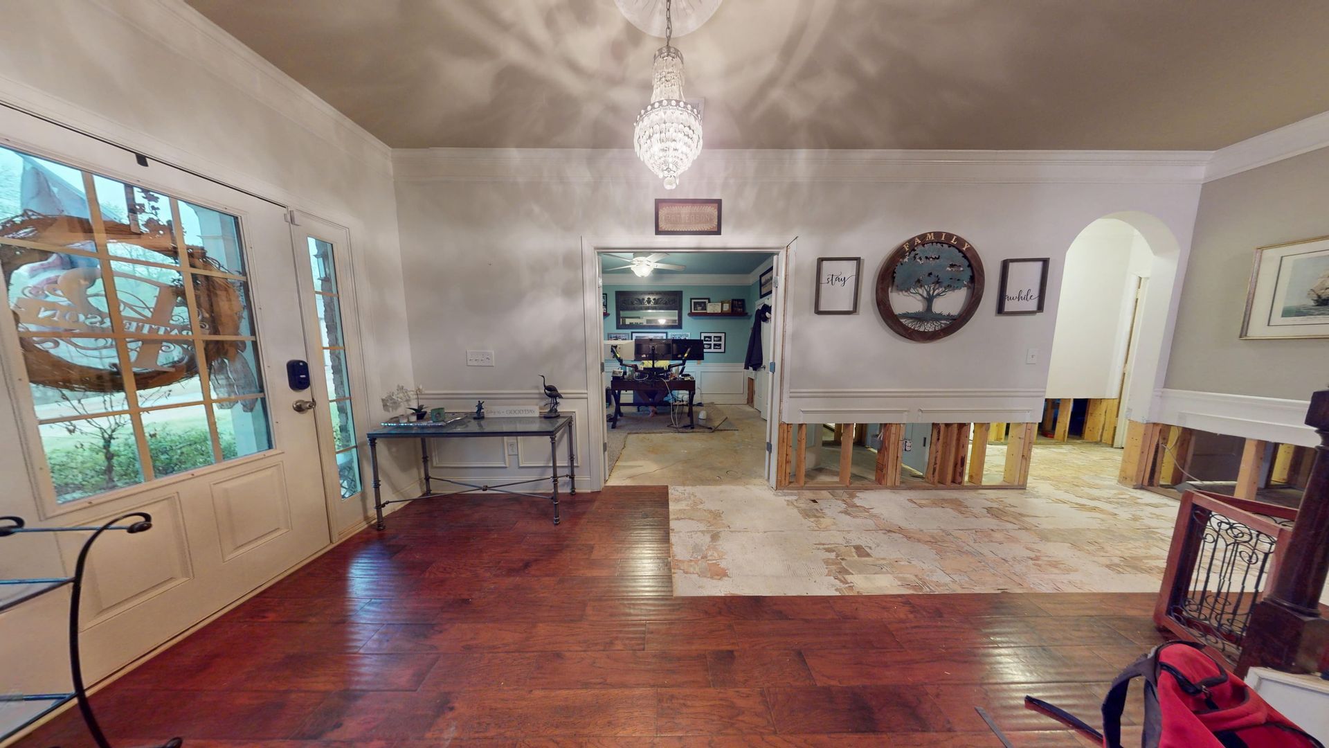 Home entryway with flood water damage to the floor before restoration