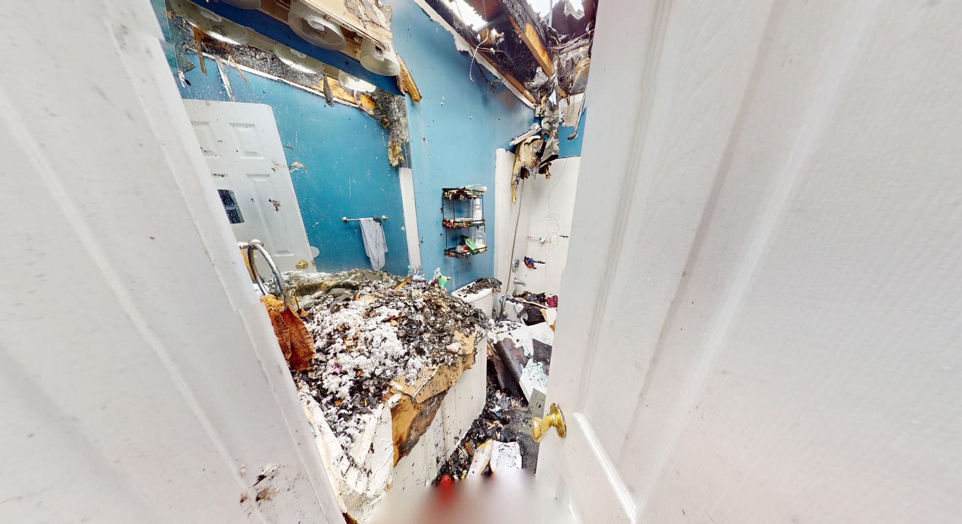 Fire damaged master bathroom before restoration in Loganville GA showing soot covered walls and heat warped fixtures