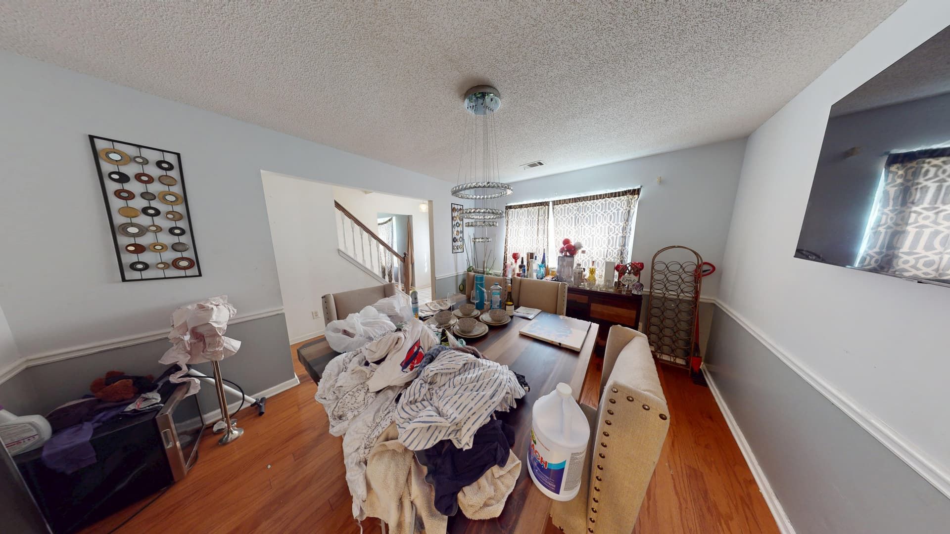 Dining room with warped flooring and water damage before restoration