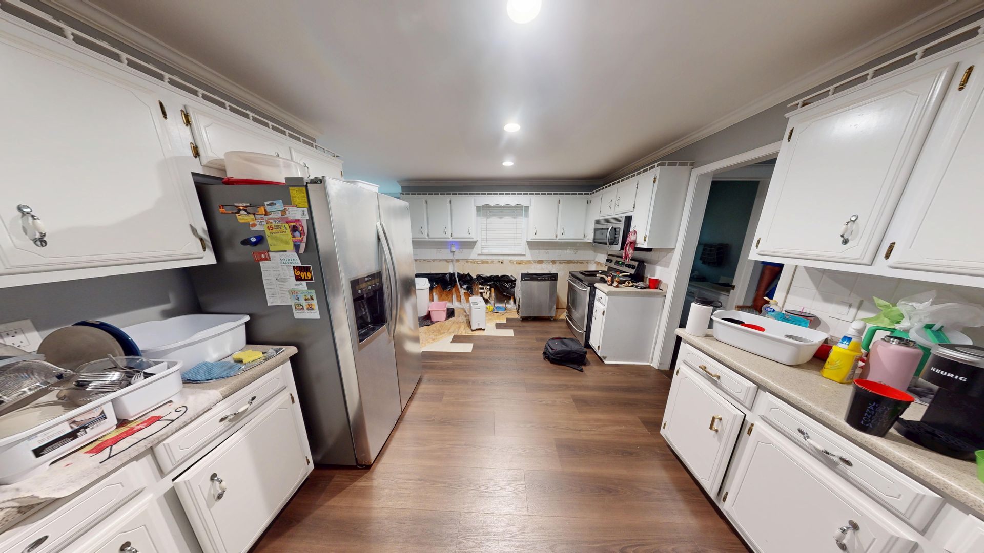 Kitchen cabinets with water damage before restoration in Snellville