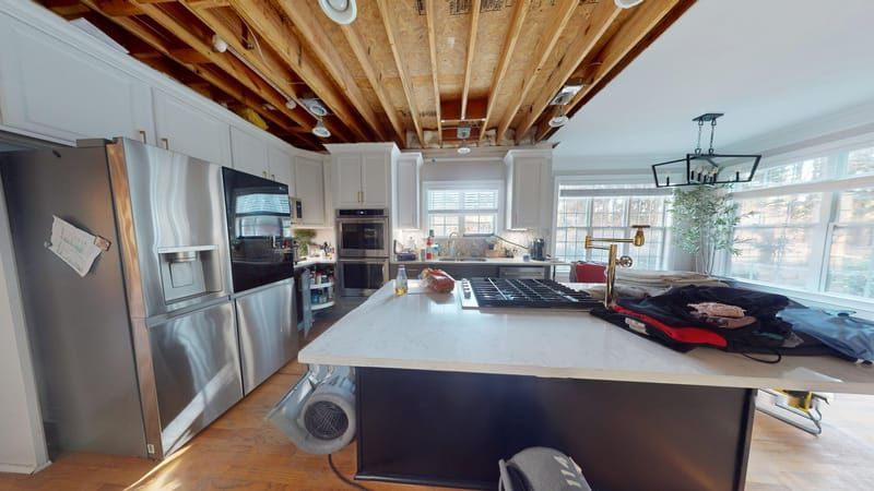 Kitchen dining area with ceiling damage during restoration