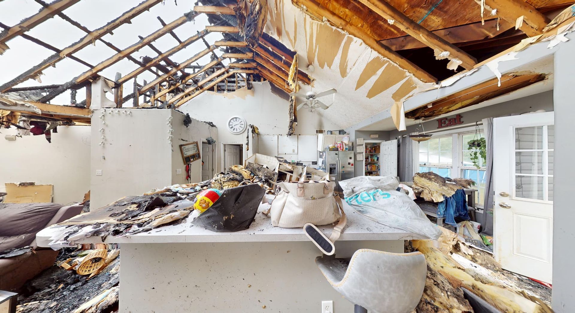 Fire gutted kitchen before professional restoration showing destroyed cabinetry and appliances