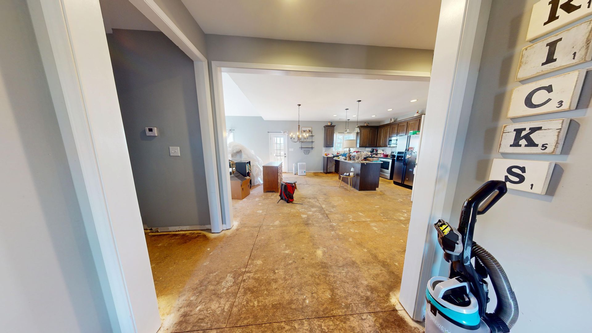 Kitchen water damage before restoration showing warped flooring
