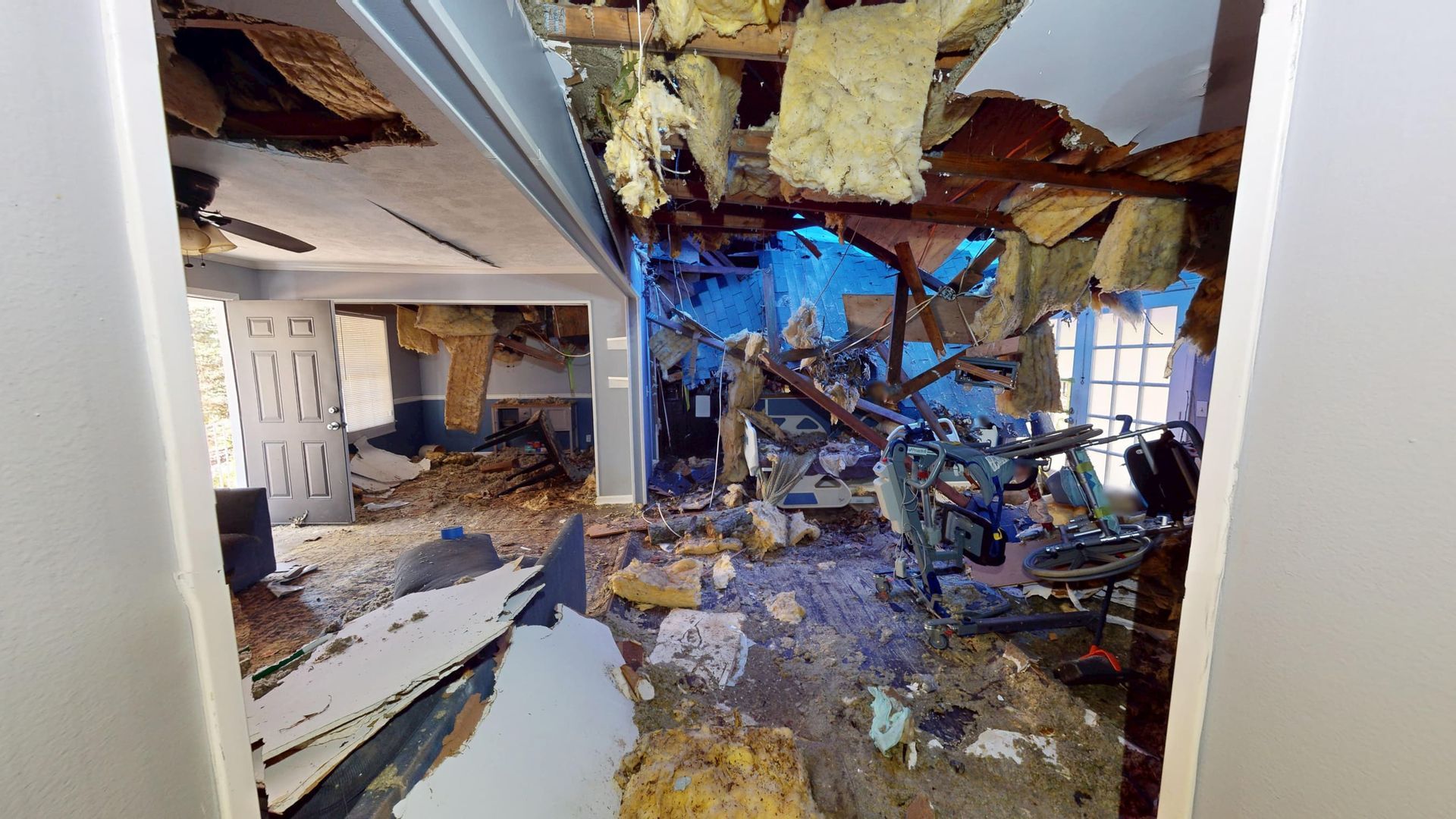 Open living room and kitchen with widespread water damage before restoration