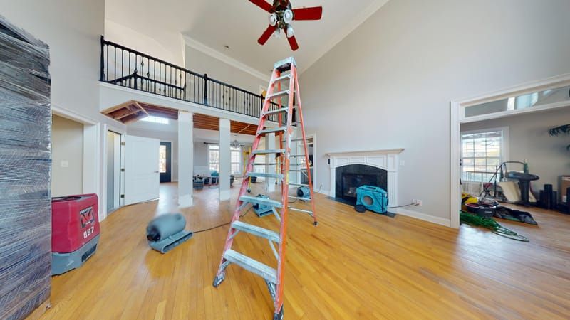 Living room showing water damage and restoration equipment