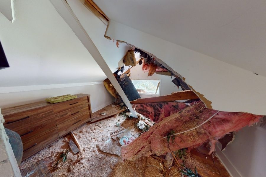 Roof and ceiling water damage inside a home after a hurricane, showing stained drywall and exposed structural damage