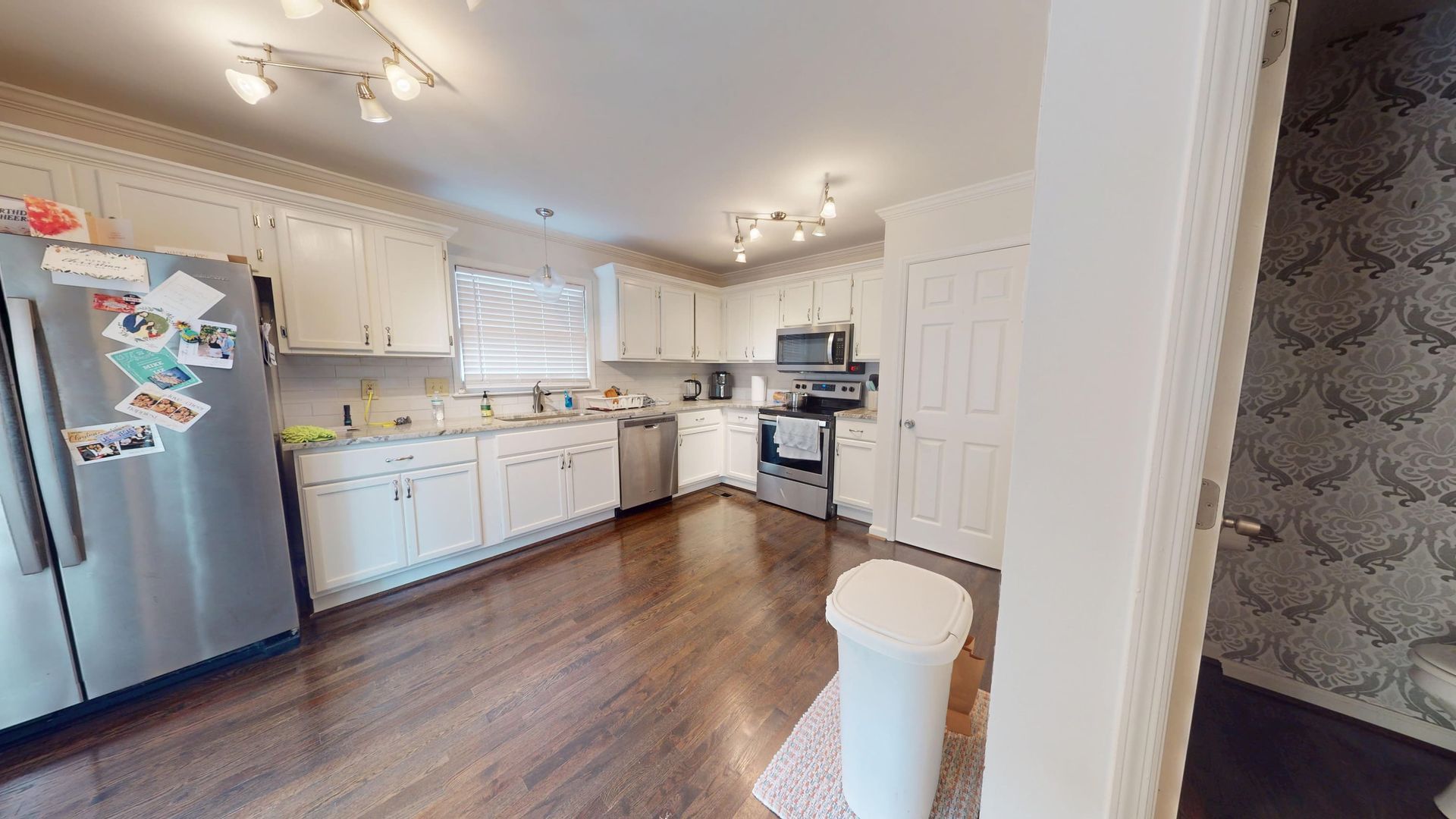Kitchen with water-damaged cabinets and wet flooring before cleanup in a Sandy Springs home