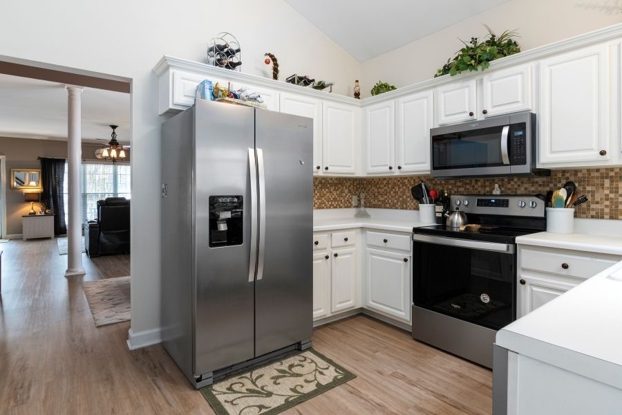 Water damage across a kitchen floor after a refrigerator water supply line burst