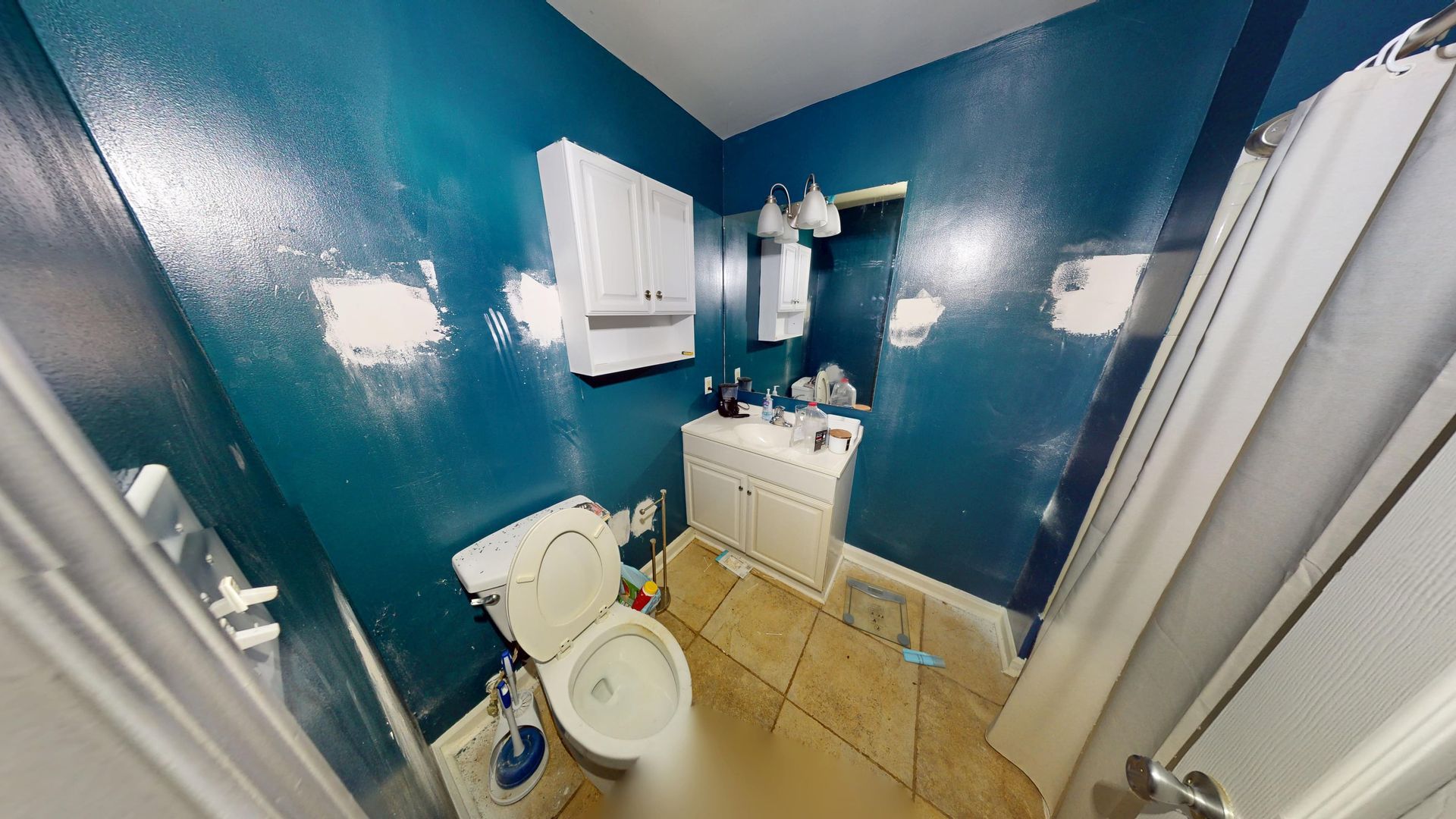 Bathroom with water damage to ceiling and walls before restoration