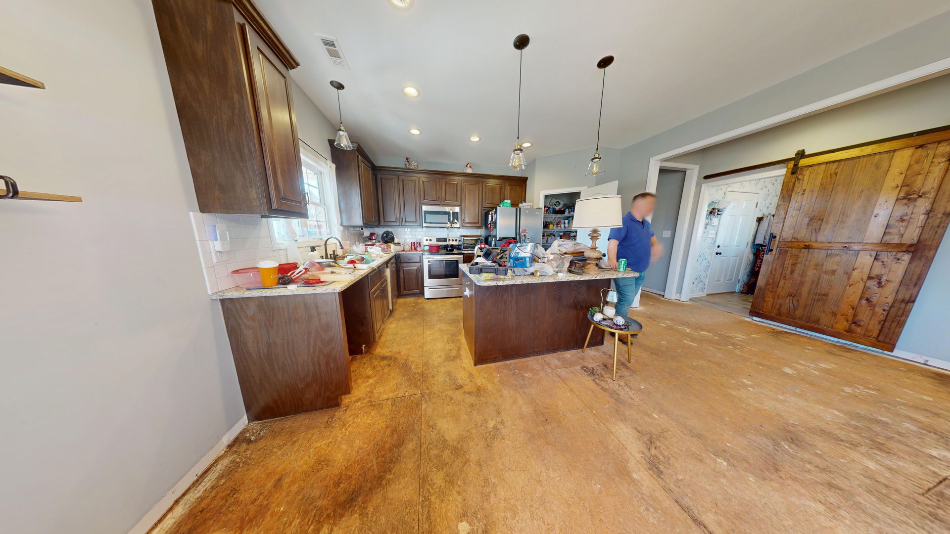Kitchen before water mitigation showing flood damage to flooring in Monroe home