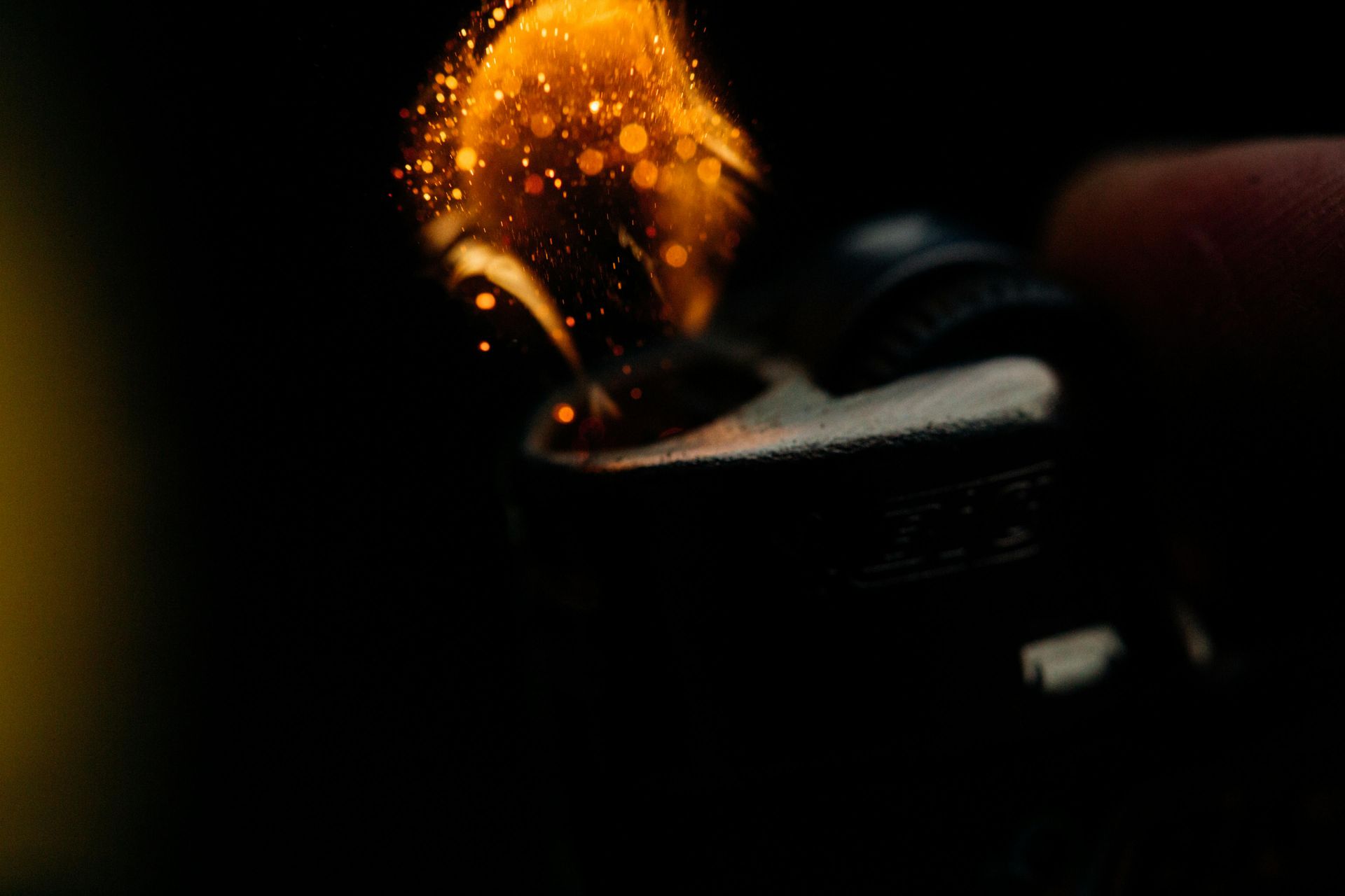 A close up of a person lighting a lighter in the dark.