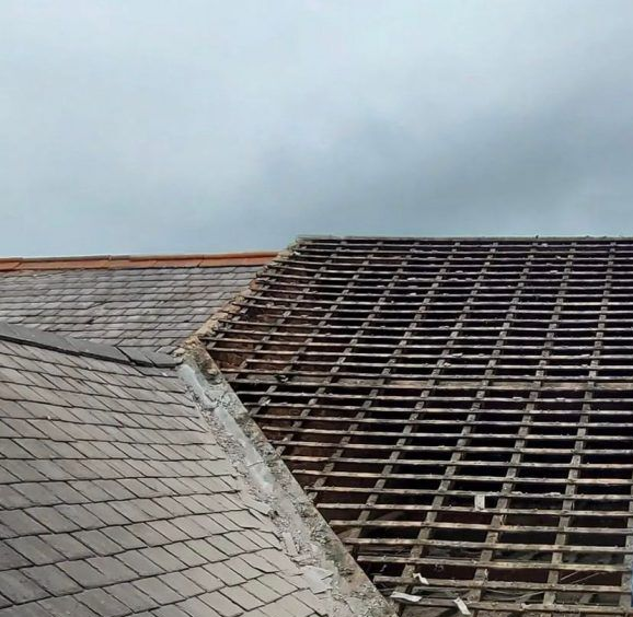 Roof with tiles removed to expose the wooden battens during roof repairs in Newmarket, Cambridgeshire.