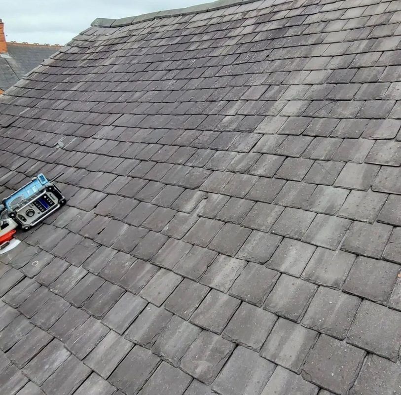 Weathered, moss-covered brown roof tiles on a residential property in Cambridge, Cambridgeshire.