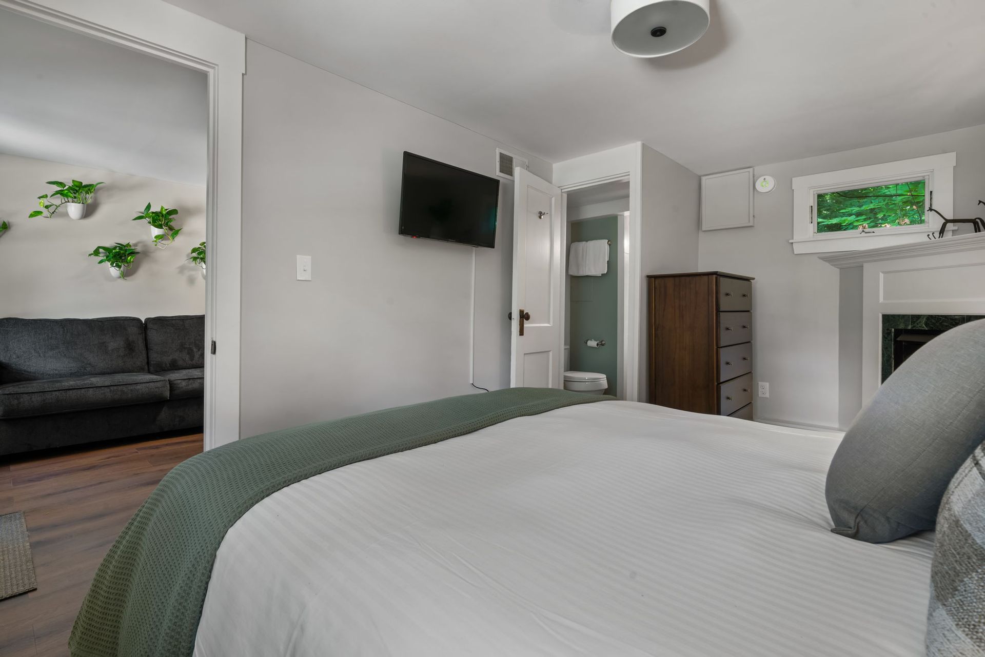 A bedroom with a bed , television , couch and fireplace.