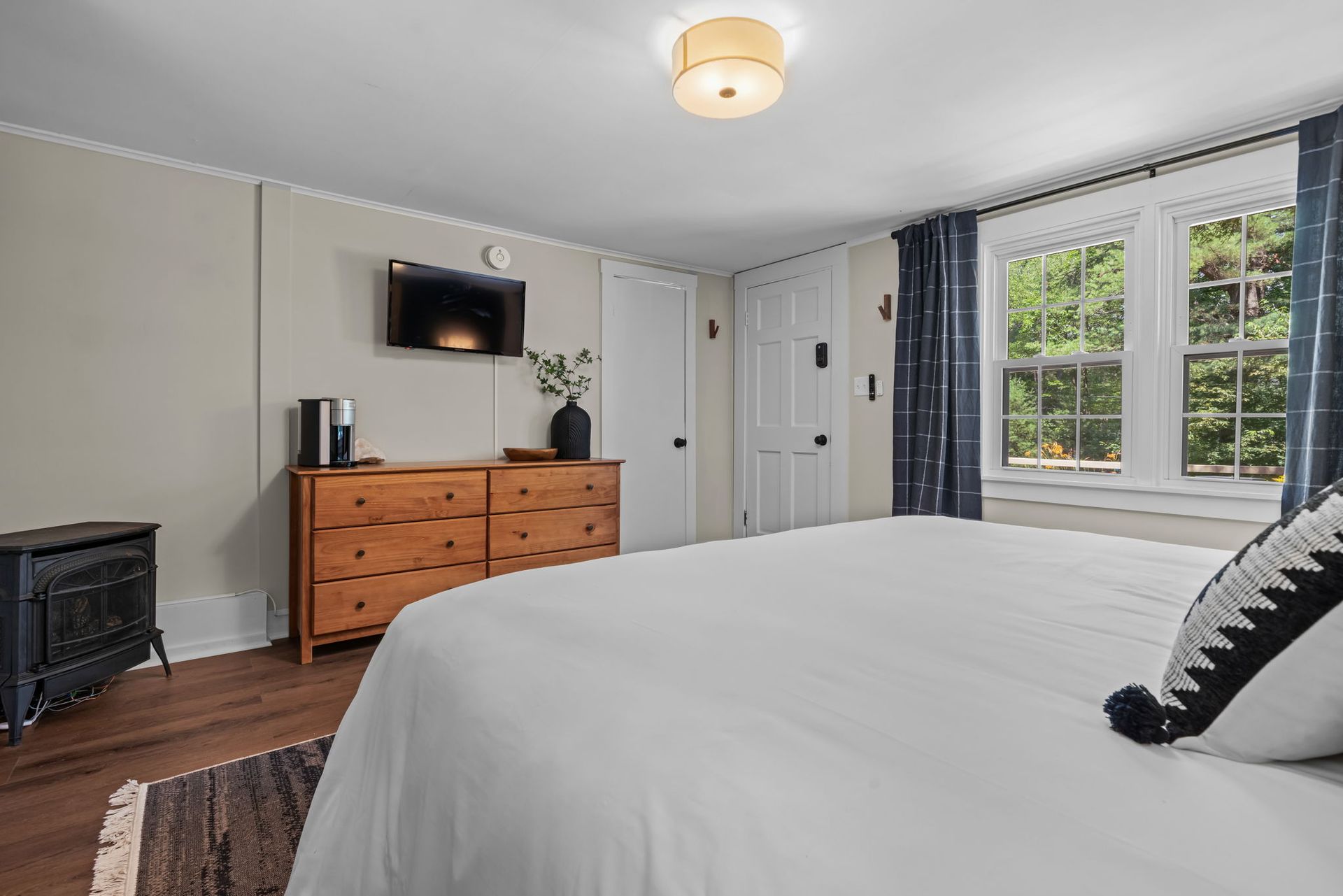 A bedroom with a king size bed , dresser , and television.