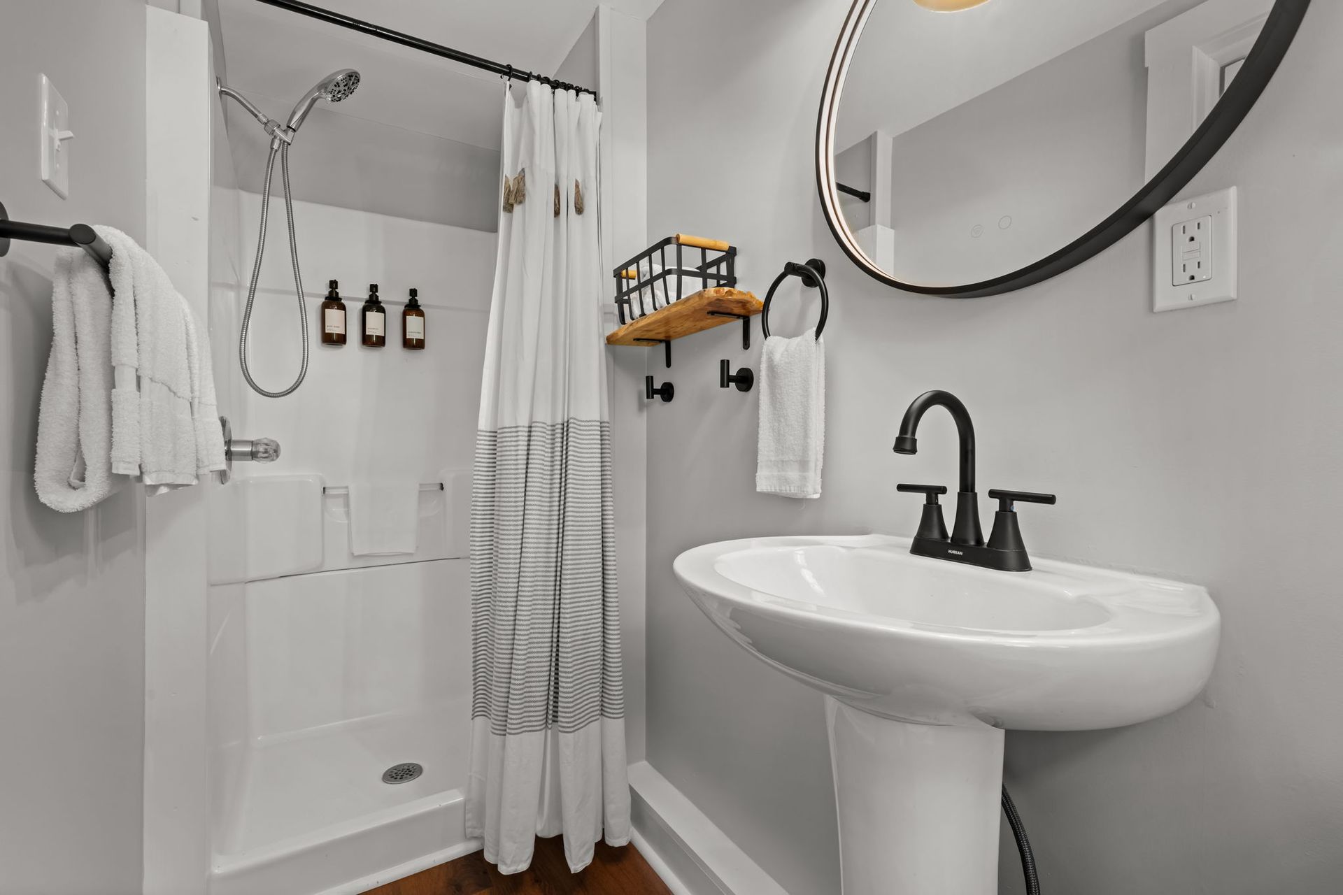 A bathroom with a sink , mirror and shower curtain.