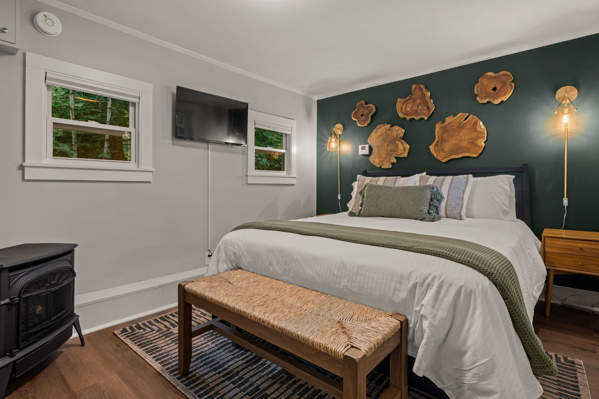 A bedroom with a king size bed , a bench , and a television.