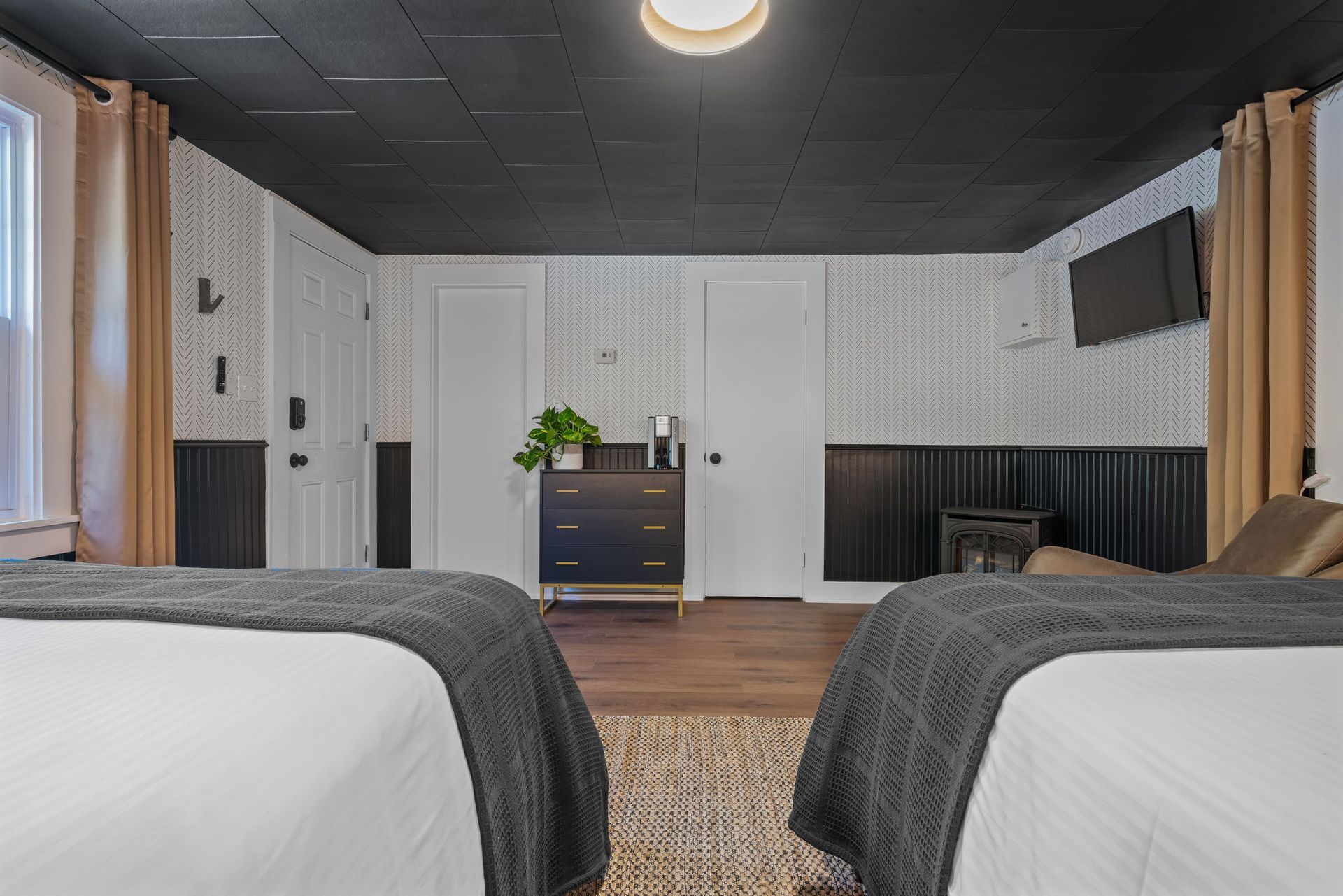 There are two beds in the room with a black ceiling.