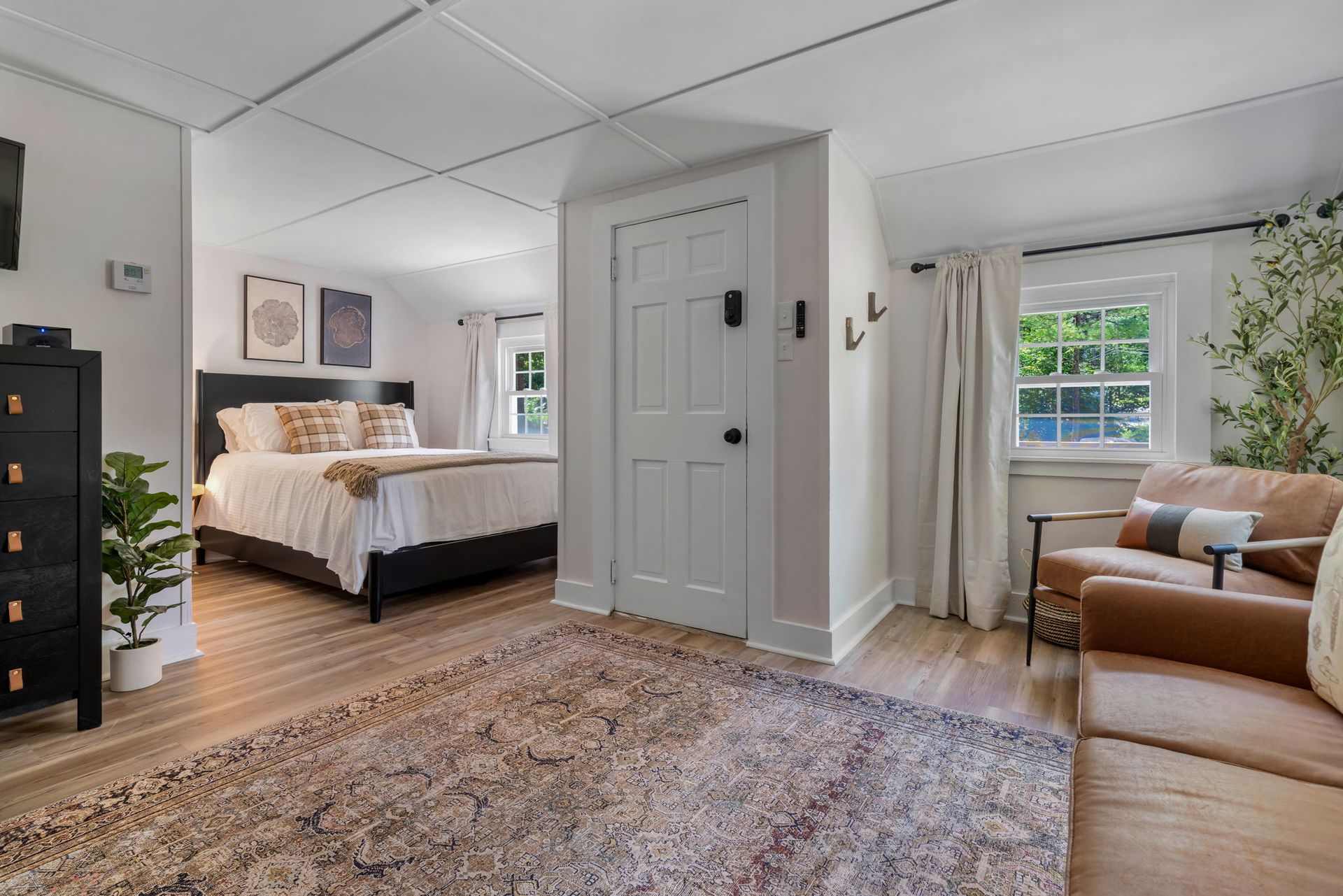 A bedroom with a bed , couch , chair and rug.
