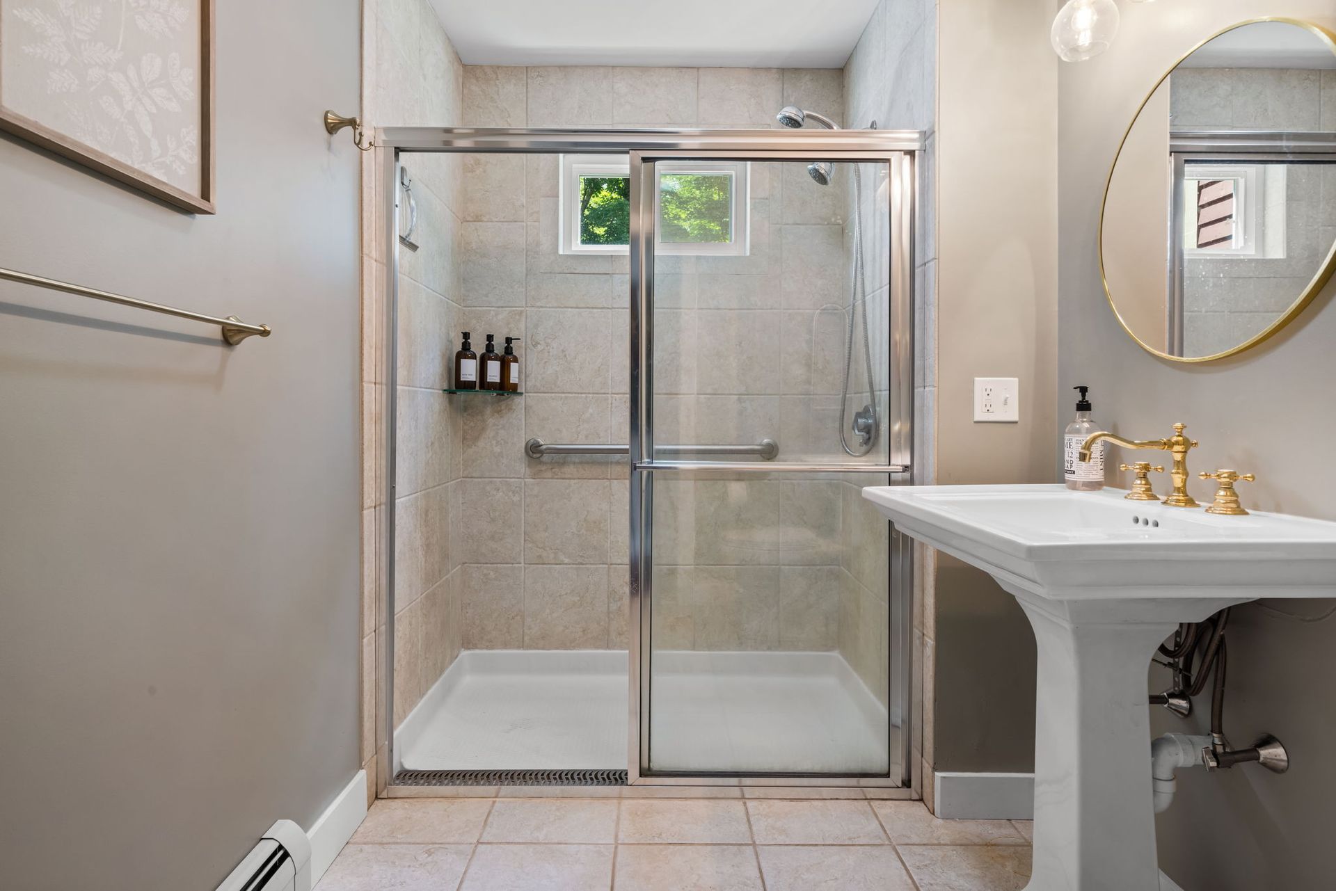 A bathroom with a sink , shower , and mirror.
