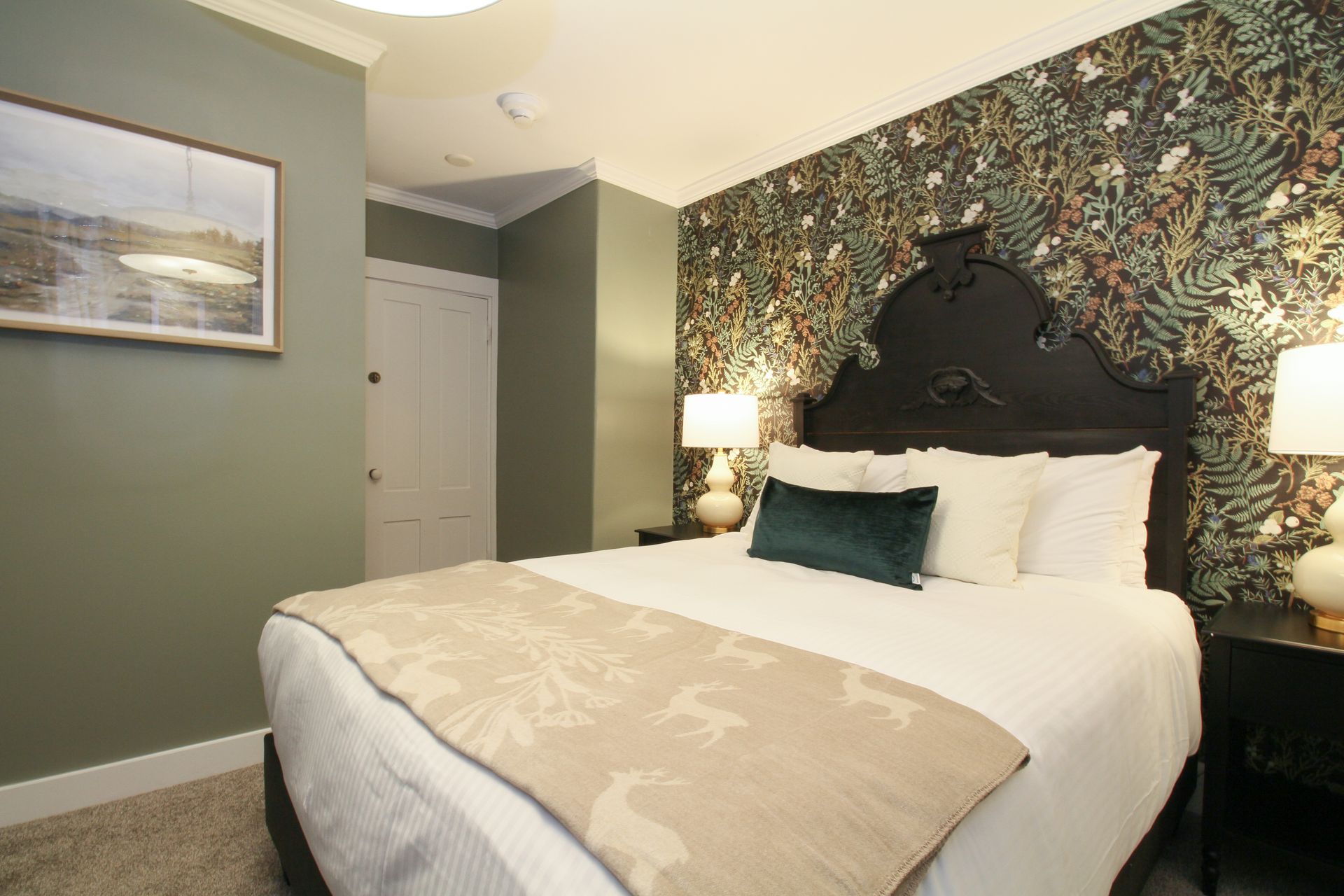 A hotel room with a large bed and a picture on the wall