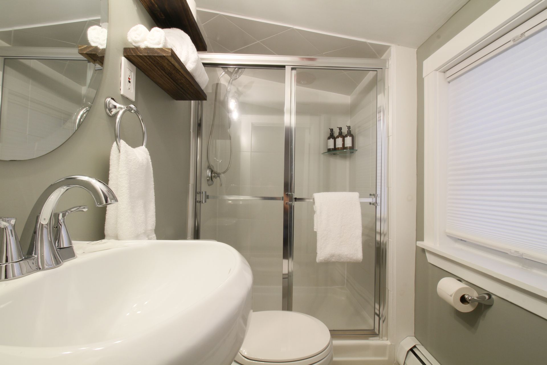 A bathroom with a sink , toilet and shower.