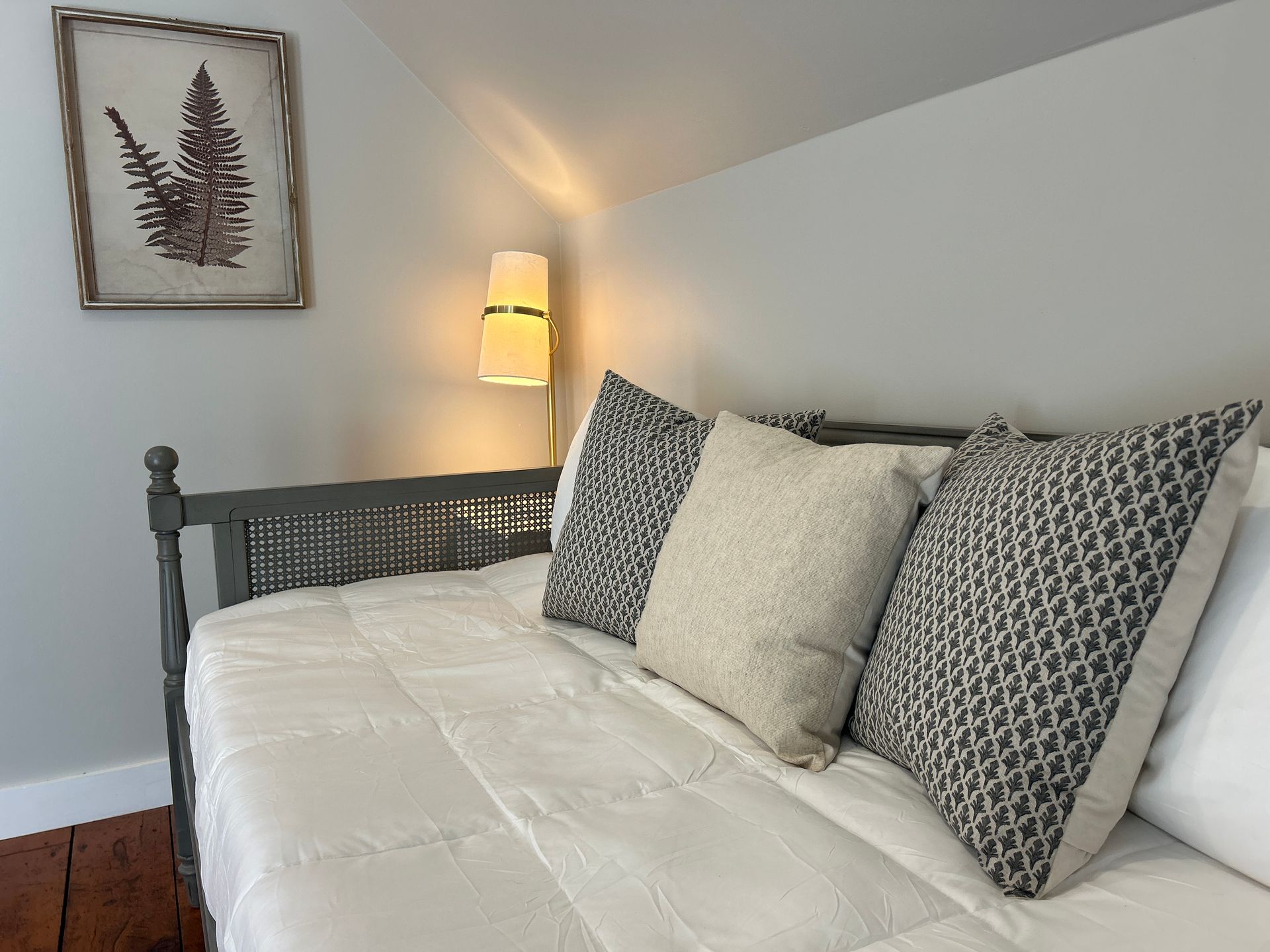 A bed with a white comforter and pillows in a bedroom.