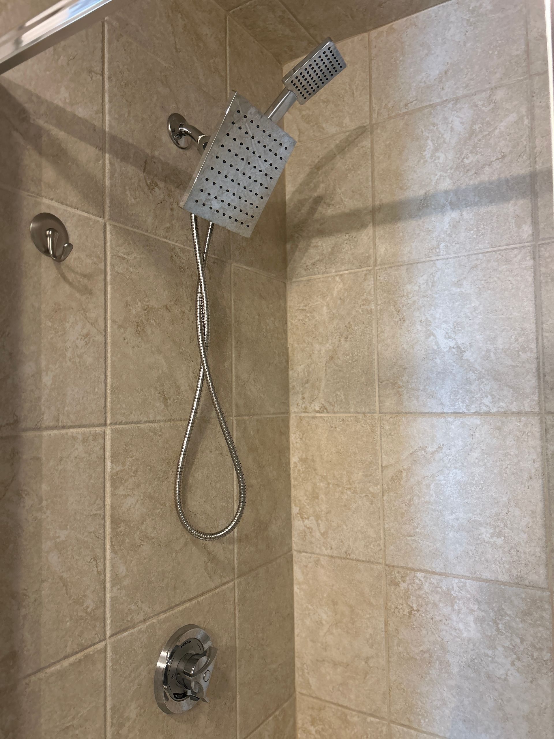 A close up of a shower head in a bathroom.