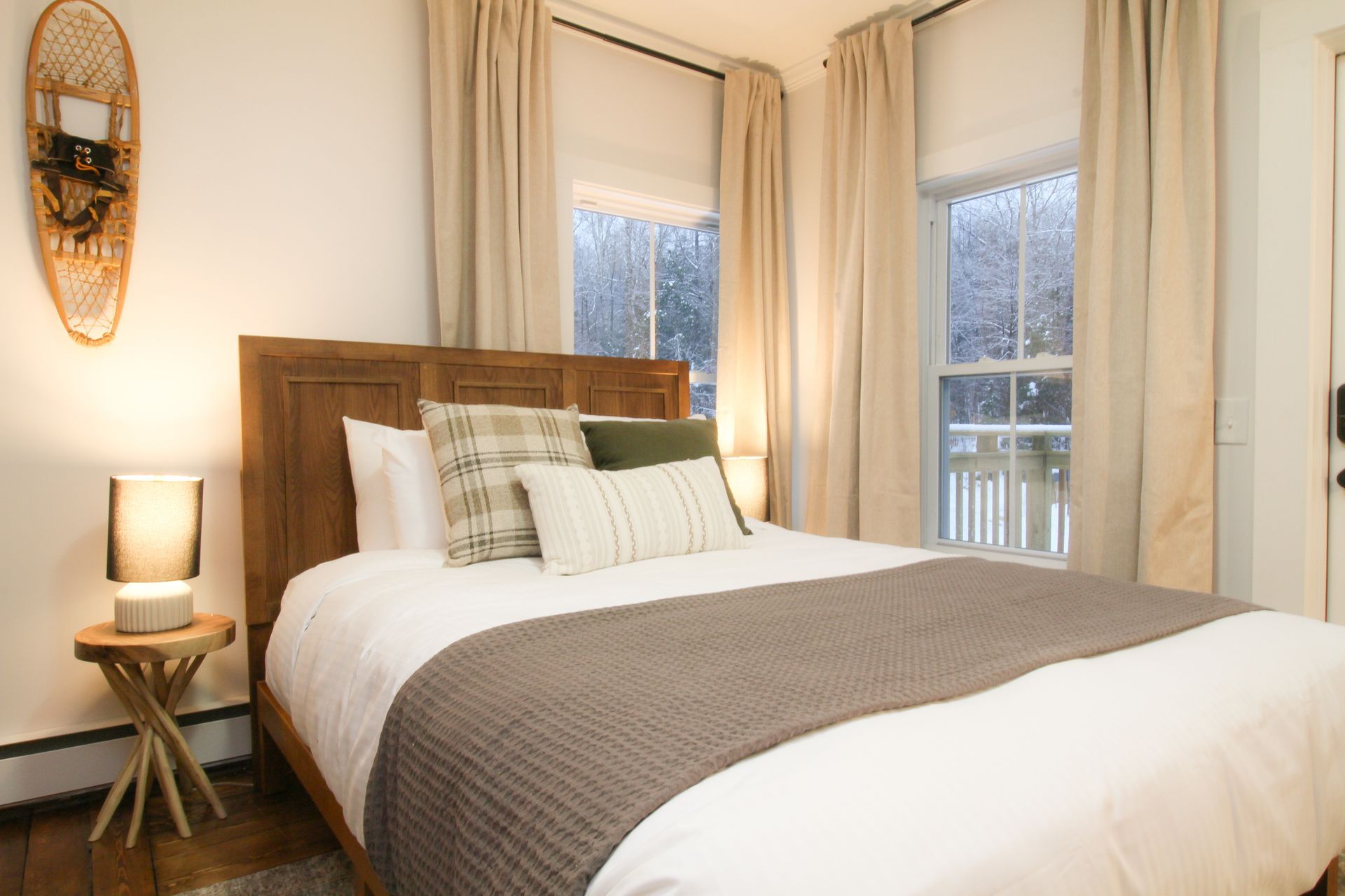 A bedroom with a bed , a lamp , and a window.