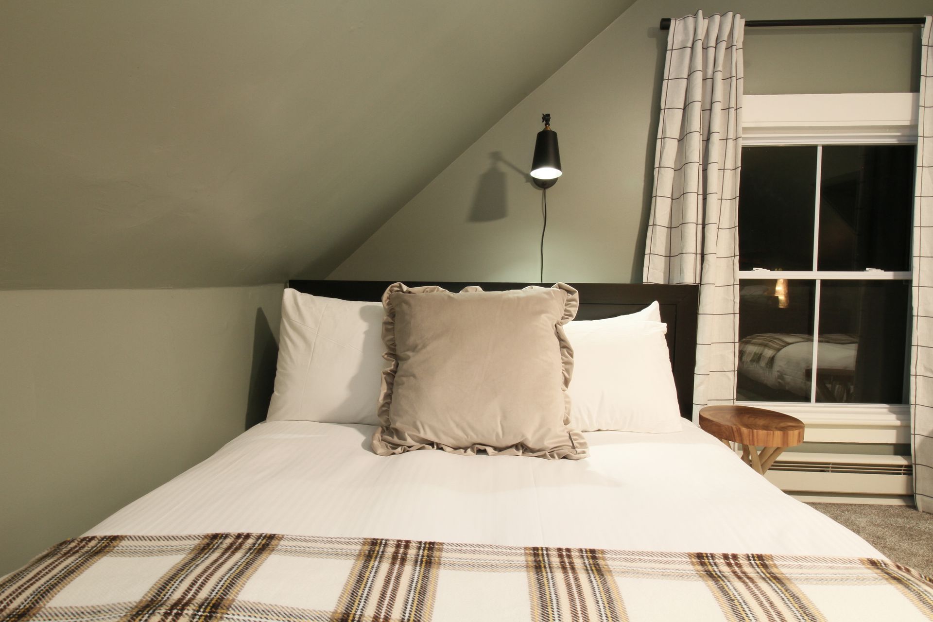 A bedroom with a king size bed and a window