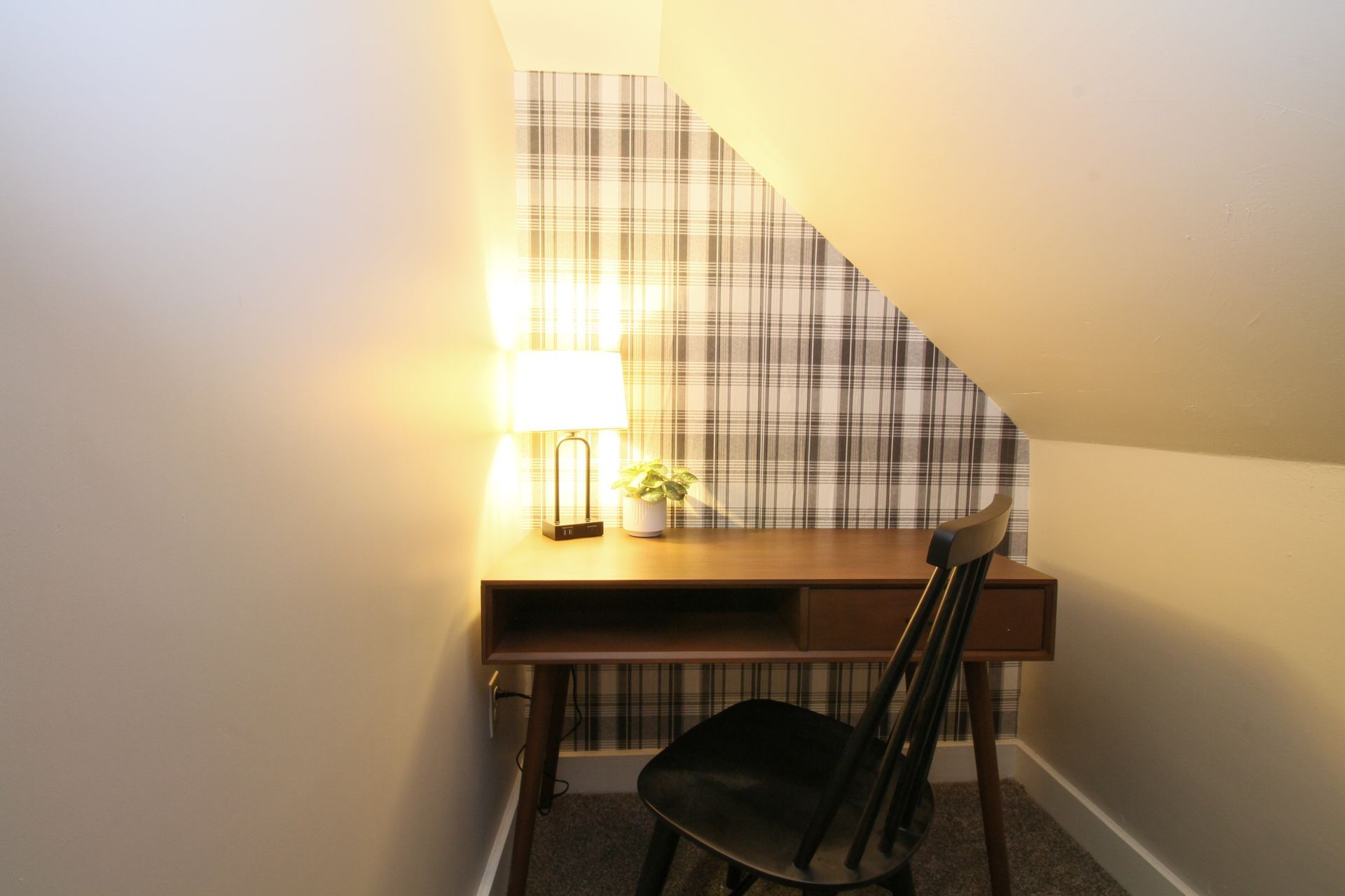 A small desk and chair in a corner of a room