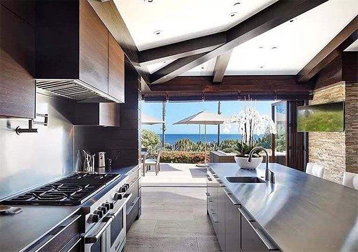 A kitchen with stainless steel appliances and a view of the ocean