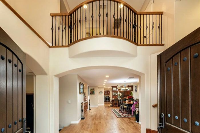 A hallway in a house with a balcony on the second floor