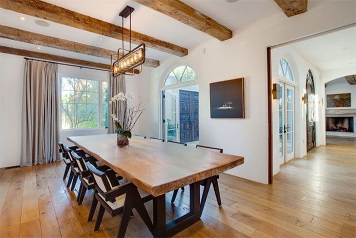 A dining room with a long wooden table and chairs.