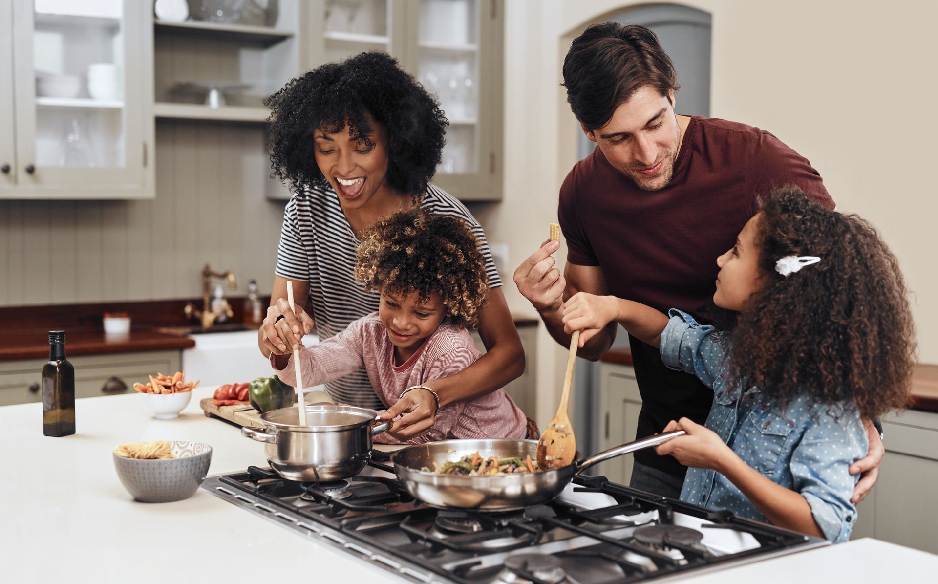 A family is cooking together in a kitchen.