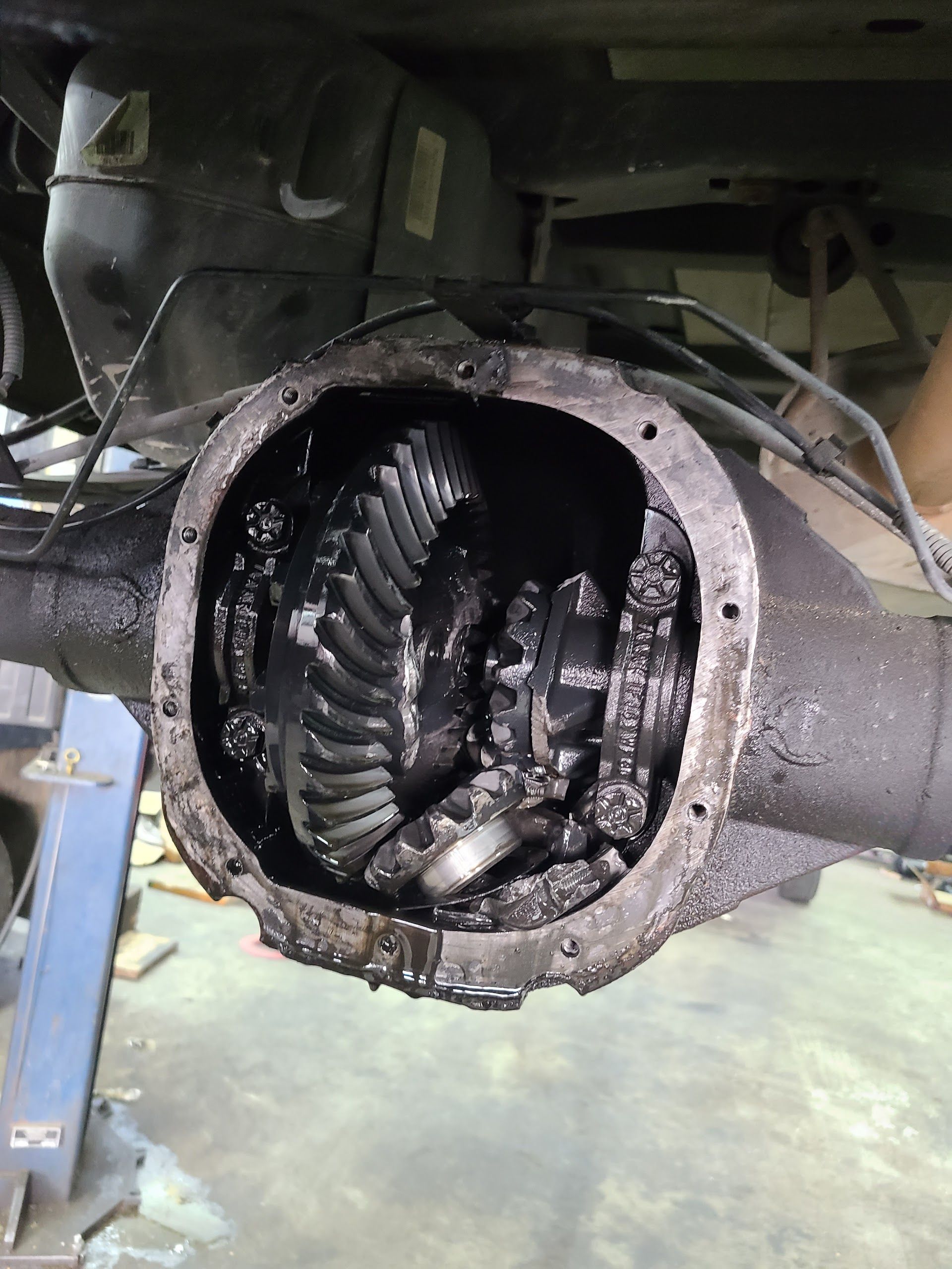 Open gear differential housing with greasy ring and pinion gears exposed inside a vehicle axle | Kingsley Auto Service