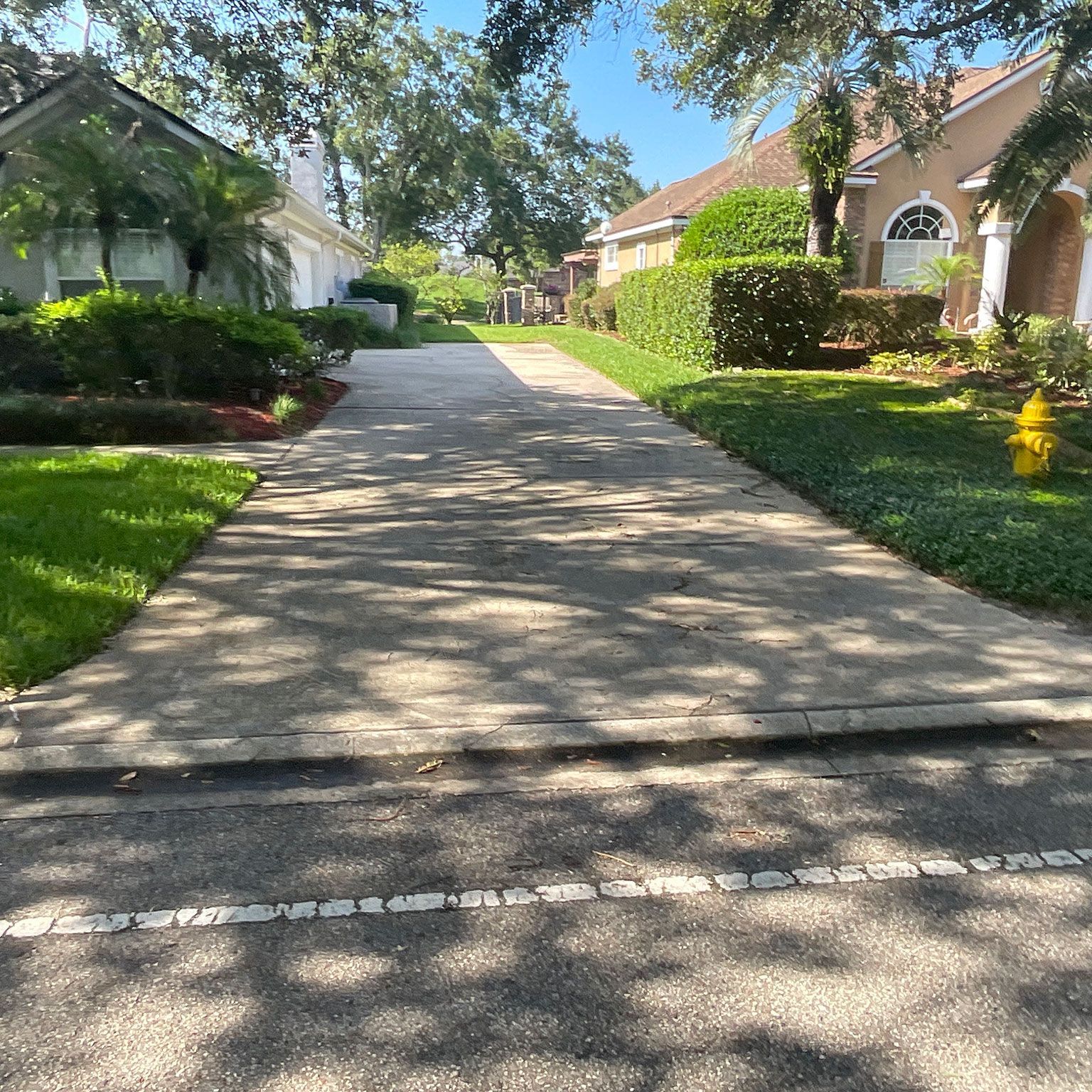 A brick driveway leading to a house with a garage.