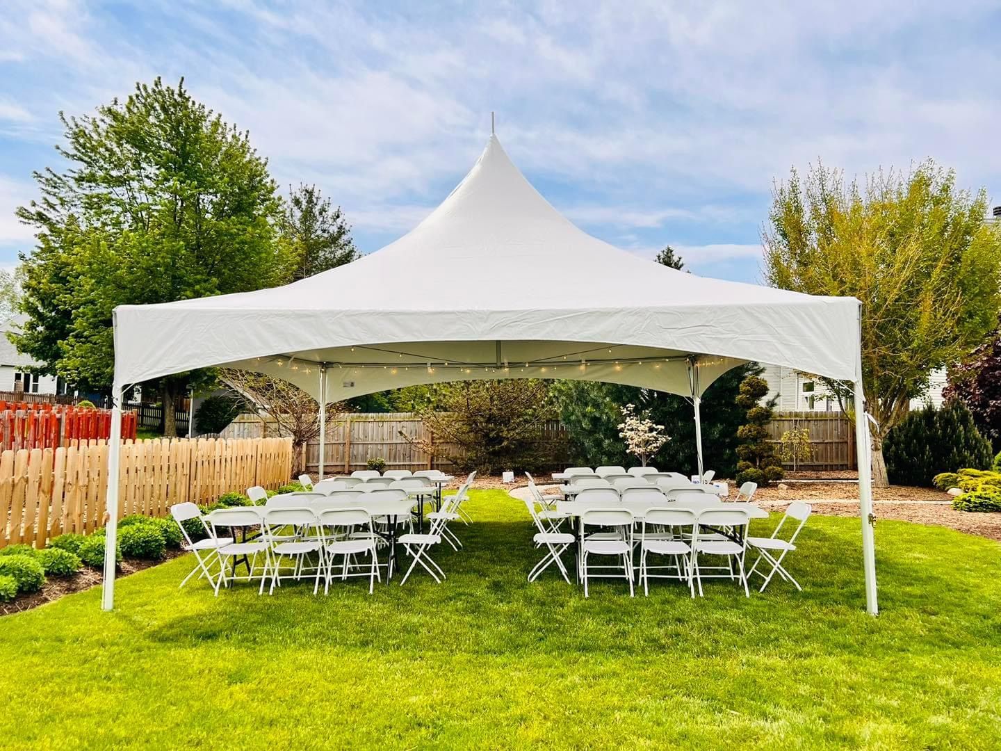 White tent set up outdoors for an event, chairs arranged in rows on grass.