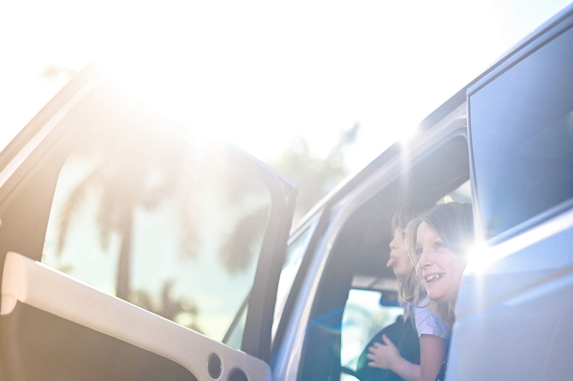 Two girls getting out of a car on a sunny day, highlighting the security auto insurance brings. Two girls getting out of a car on a sunny day, highlighting the security auto insurance brings.