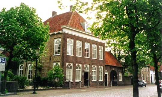 Luchtfoto van de stervormige vestingstad Willemstad in Nederland, omgeven door een gracht, velden en een rivier.