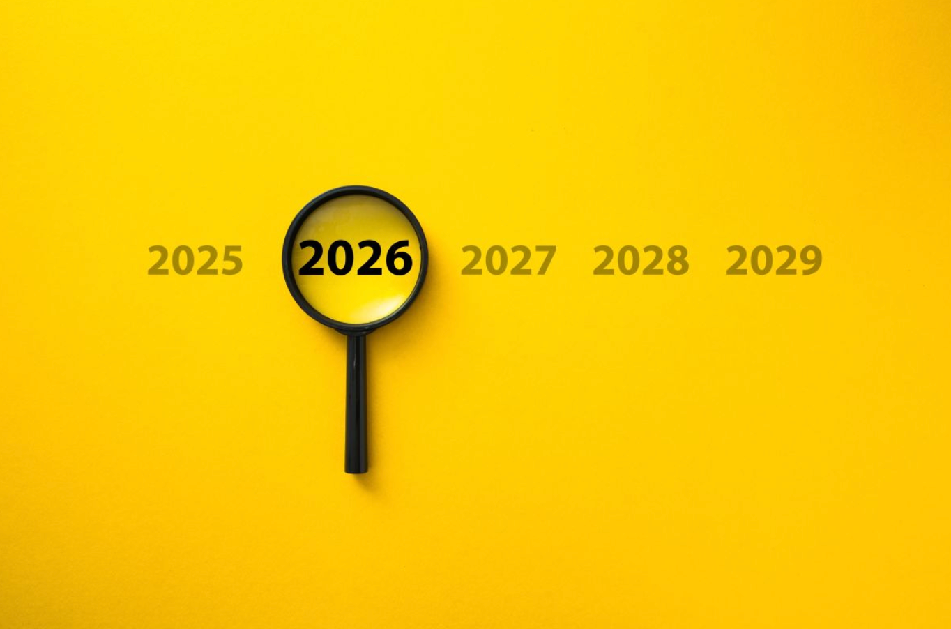 Een vergrootglas zoomt in op het jaar 2026, met de jaren 2025, 2027, 2028 en 2029 op de achtergrond, tegen een gele ondergrond.